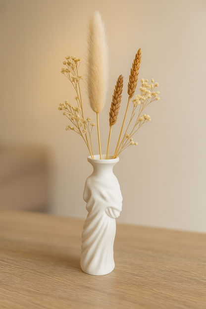 „Schmale, weiße Vase in Form eines drapierten Torsos mit Trockenblumen; Höhe 15 cm, Öffnung 30 mm.“